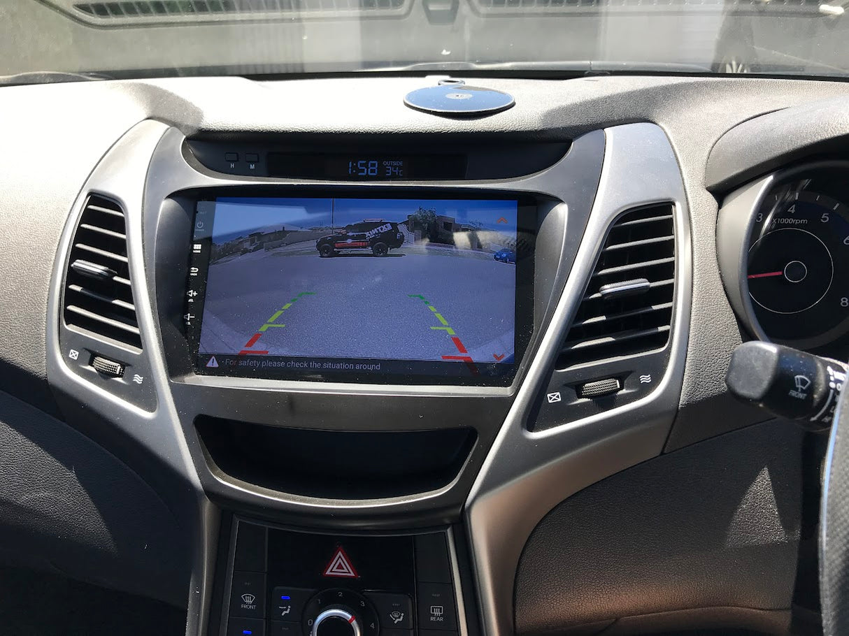 Car dashboard with an Extnix head unit navigation screen displaying a rearview camera view.