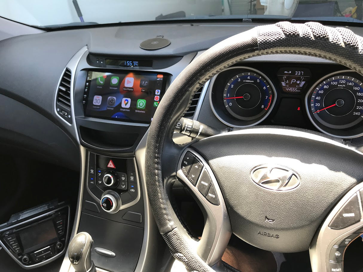 Car interior with steering wheel and dashboard showing Hyundai logo Driver view of Extnix head unit