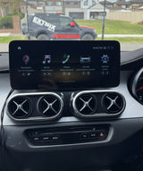 Car dashboard with infotainment system display and EXTINX truck in the background