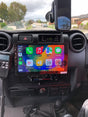 An Extnix Premium wireless Apple CarPlay infotainment system installed in a Toyota Landcruiser vehicle, featuring a touchscreen interface.