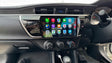 Corolla Sedan dashboard with a touchscreen display showing Carplay app icons.